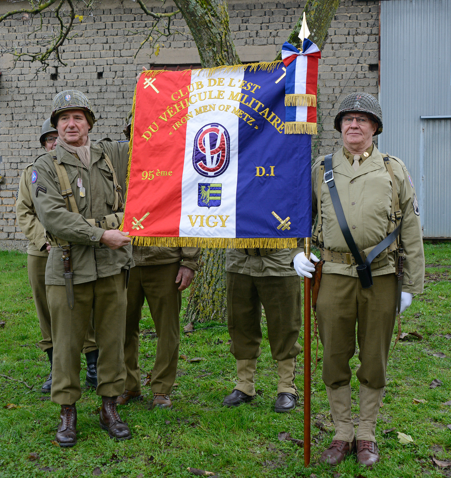 Located in Vigy, the Club de l’Est du Véhicule Militaire association dedicated a new flag recognizing the 95th ID. Task Force Bacon, comprised of the 2nd Battalion, 378th Regiment, and 1st Battalion, 377th Regiment, 95th ID liberated Vigy November 17-18, 1944. With a tricolored background of blue, white and red representing the French flag, the CEVM’s new flag bears the 95th Infantry Division’s emblem, the Coat of Arms of the village of Vigy and four images of the double-barred Cross of Lorraine. The Cross of Lorraine was used as a symbol of Free France during World War II.