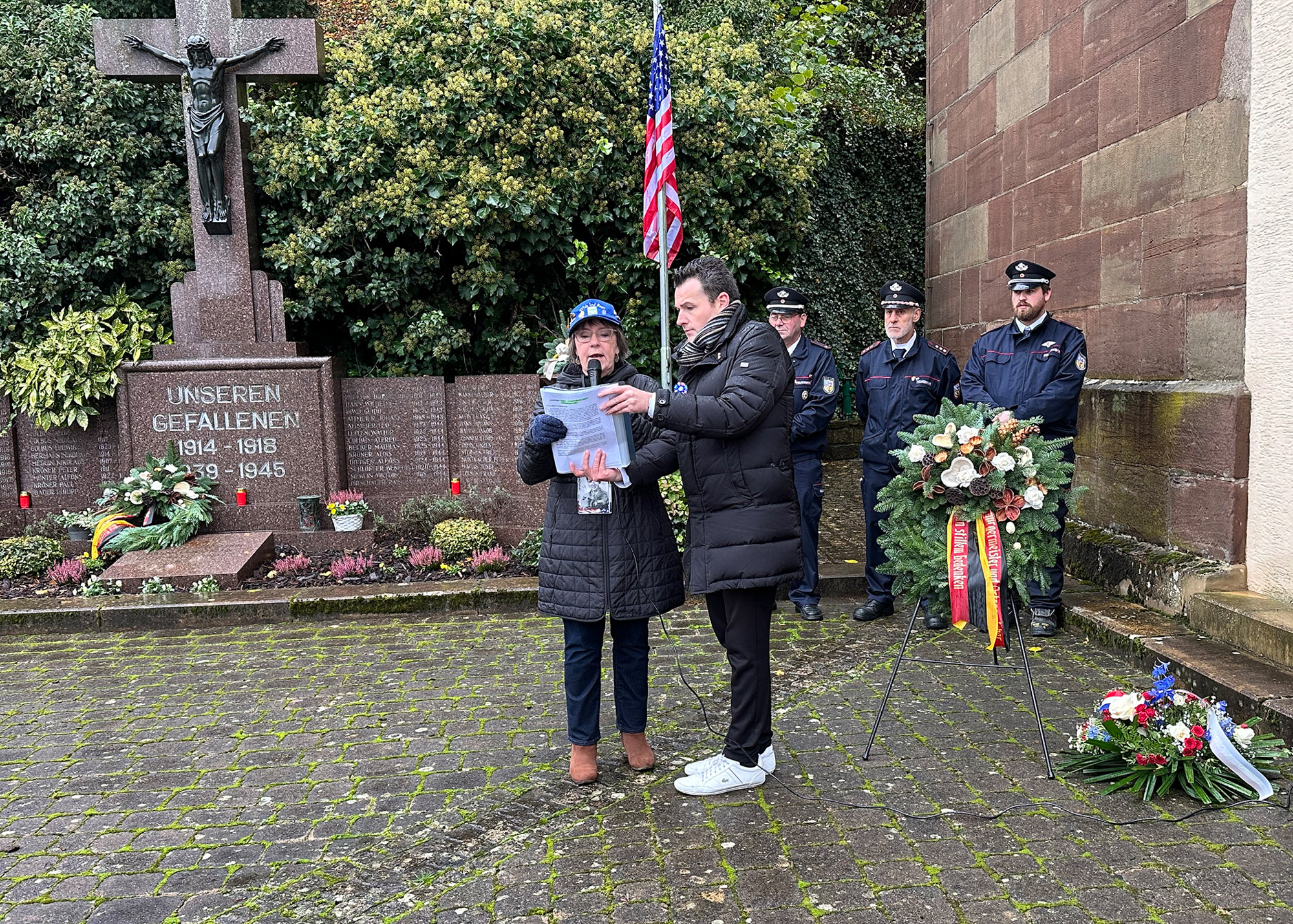 During a memorial service for the 95th's only Congressional Medal of Honor recipient, Andrew Miller, Nancy Bubb reads an account of Miller's heroic actions and death near Hemmersdorf. Nancy's father, John Komp, Co. G, 377th Reg., was Miller's commanding officer. It was a rainy, blustery day, so the mayor of the district of Kerpich Hemmersdorf, Joshua Pawlak, helped hold Nancy's notes.