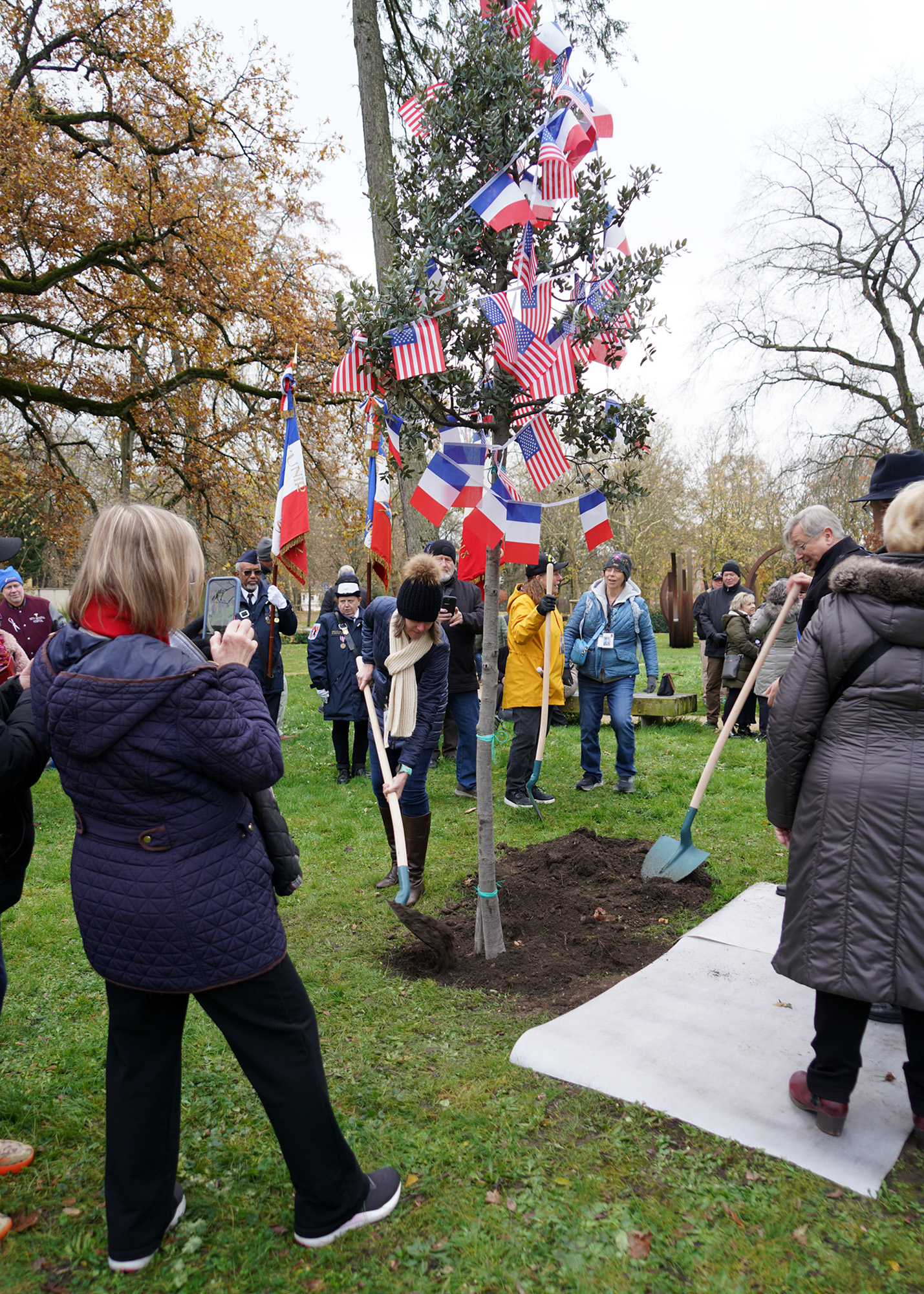 Darcy Flora helps with the planting in remembrance of her grandfather, Edward DeWayne Snell, Co. F, 378th Reg.