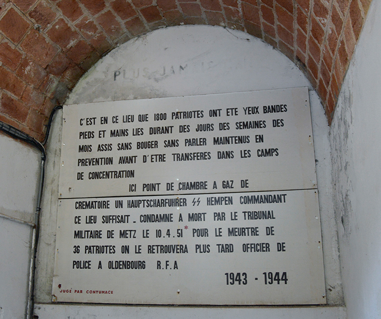 Never Again. It was in this place that 1,500 to 1,800 patriots were blindfolded, bound hand and foot, for days, weeks, months, sitting without moving, without speaking, kept in preventive detention before being transferred to the concentration camps. Here, there was no gas chamber, no crematorium, SS Chief Sergeant Hempen commanding this place was enough, sentenced to death by the military tribunal of Metz on April 10,1951 for the murder of 36 patriots. He was later found as a police officer in Oldenburg, Federal Republic of Germany.