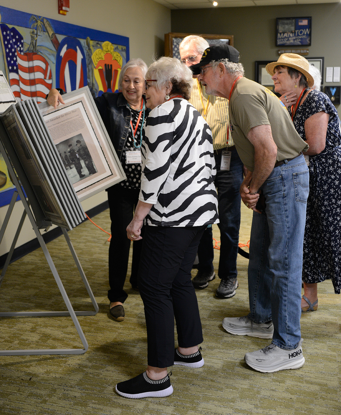 Mary Gomez Curll, Kim Urbon, Clif Twaddle, Ted Cox and Nancy Bubb check out World War II-era newspaper clippings about the 95th Infantry Division at the 95th Memorial May 17, 2024.