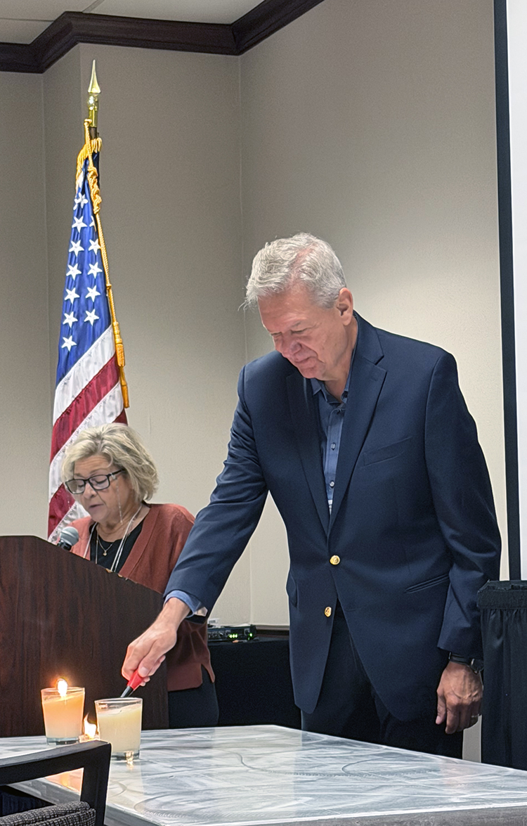 Nancy Broadway reads the name and a short biography of Iron Man Pasquale Catalano as Jim Broadway lights a candle in remembrance of the only known Iron Man to have passed since the 2025 reunion. Nancy also remembered friends of the 95th who passed away in the past year.